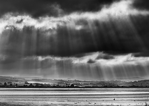 Streams of sunlight breaking through the cloud over the Exe estuary, Devon.